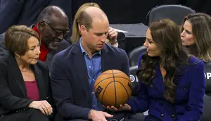 Kate Middleton, Putri Wales memberikan bola basket kepada Pangeran Inggris William disaksikan Gubernur terpilih Massachusetts Maura Healey (kiri) selama pertandingan NBA antara Boston Celtics dan Miami Heat di TD Garden di pusat kota Boston, pada 30 November 2022. (Photo by Brian Snyder/Pool/AFP)