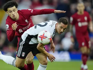 Gelandang Liverpool Curtis Jones berebut bola dengan bek Cedric Soares  Fulham dalam laga tunda pekan ke-28 Premier League 2022-2023 di Anfield, Kamis (4/5/2023). (AP Photo/Jon Super)