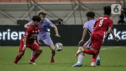 Pemain Indonesia All Star U-20 Andre Oktaviansyah (kiri) berebut bola dengan pemain FC Barcelona U-18 pada pertandingan International Youth Championship 2021 di Jakarta International Stadium, Jakarta, Rabu (13/4/2022). Pertandingan berakhir imbang 0-0. (Liputan6.com/Faizal Fanani)