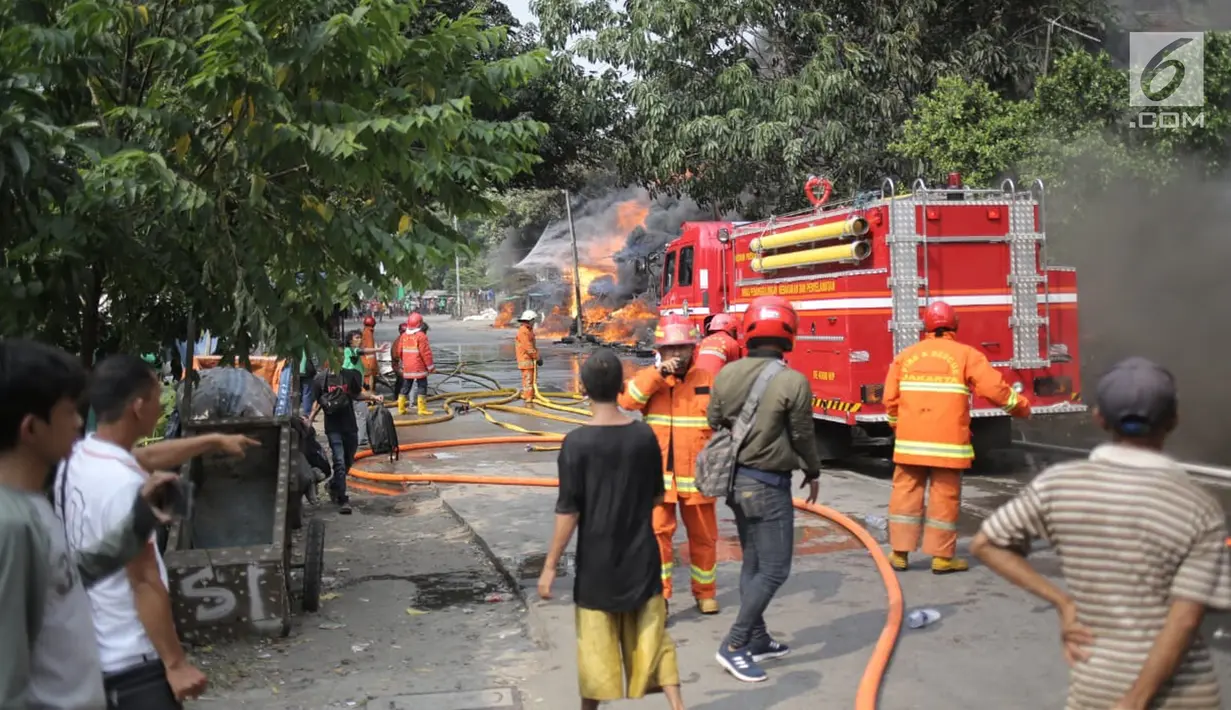 Petugas pemadam kebakaran berusaha memadamkan api yang melalap gudang di Jalan Kampung Bandan, Ancol, Jakarta Utara, Kamis (5/7). Petugas pemadam kebakaran menurunkan 17 unit mobil damkar untuk memadamkan api. (Liputan6.com/Faizal Fanani)