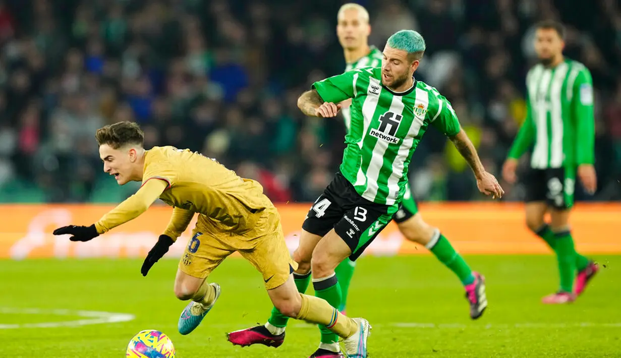 Pemain Barcelona Gavi (kiri) berebut bola dengan pemain Real Betis Aitor Ruibal pada pertandingan sepak bola Liga Spanyol di Stadion Benito Villamarin, Seville, Spanyol, 1 Februari 2023. Barcelona genap mengoleksi 50 poin dan unggul 8 poin dari Real Madrid usai menang 2-1 atas Real Betis pada lanjutan Liga Spanyol. (AP Photo/Jose Breton)