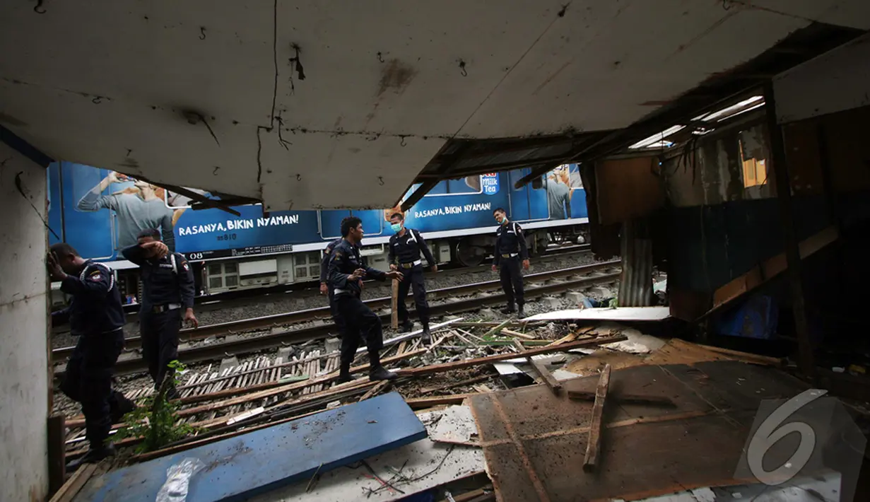 Petugas membongkar bangunan liar yang berada di Bantaran Rel Stasiun Pasar Minggu, Jakarta, Selasa (30/12/2014). (Liputan6.com/Faizal Fanani)