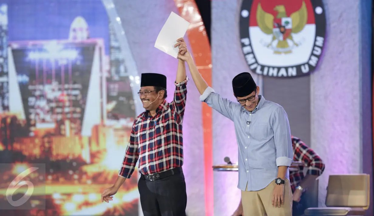 Djarot Saiful Hidayat mengangkat tangan Sandiaga Uno usai debat terakhir Pilgub DKI Jakarta 2017 di Hotel Bidakara, Jakarta, Rabu (12/4). Pada debat terakhir ini mengangkat tema 'Dari Masyarakat untuk Jakarta'. (Liputan6.com/Faizal Fanani)