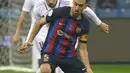 Gelandang Barcelona, Sergio Busquets mengontrol bola dari kawalan gelandang Real Madrid, Federico Valverde selama pertandingan final Piala Super Spanyol di Stadion Internasional Raja Fahd di Riyadh, Arab Saudi, Senin (16/1/2023). Barcelona kini mengoleksi 14 gelar juara sejak Piala Super Spanyol kali pertama digelar pada 1982. (AFP/Fayez Nureldine)