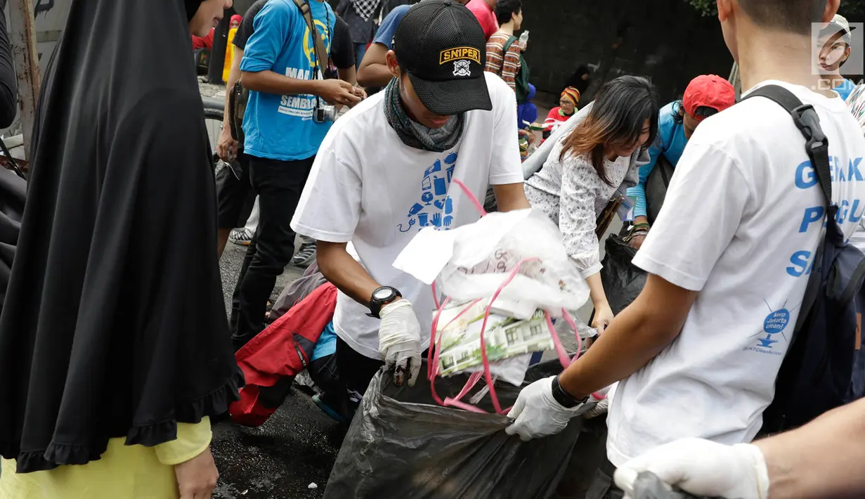 Relawan mengumpulkan sampah di lokasi Car Free Day (CFD), Jakarta, Minggu (21/5). Kegiatan tersebut diadakan untuk mengajak masyarakat agar peduli dengan kebersihan lingkungan serta selalu membuang sampah pada tempatnya. (Liputan6.com/Immanuel Antonius)
