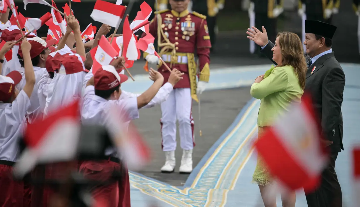 Kedatangan Presiden Peru, Dina Ercilia Boluarte Zegarra di Istana Merdeka disambut meriah sejumlah pelajar dari Sekolah Menengah Pertama (SMP) dan Sekolah Dasar (SD) yang masih menggunakan seragam. Para pelajar tersebut juga mengibar-ngibarkan bendera Indonesia dan Peru. (Bay ISMOYO/AFP)
