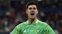 Kiper Real Madrid, Thibaut Courtois melakukan selebrasi usai berhasil memenangkan laga final Liga Champions antara Liverpool melawan Real Madrid yang berlangsung di Stade de France, Saint Denis, Sabtu, 28 Mei 2022 waktu setempat. (AFP/Javier Soriano)