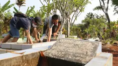 Pelanggar PSBB dihukum membersihkan makam di kawasan Stadion Pakansari, Kabupaten Bogor, Minggu (6/9/2020). Pemkab Bogor menghukum pelanggar PSBB dengan denda Rp 100 ribu serta sanksi sosial seperti membersihkan area makam, push up, dan mempraktikkan prosesi pemakaman. (Liputan6.com/Herman Zakharia)