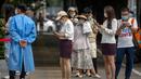 Orang-orang yang memakai masker berbaris untuk tes COVID-19 di fasilitas pengujian virus corona di Beijing, China, Jumat (12/8/2022). Tujuannya adalah untuk menghindari mengubah upaya untuk menghentikan wabah menjadi mimpi buruk yang berkepanjangan yang terlihat di Shanghai dan Wuhan. (AP Photo/Mark Schiefelbein)