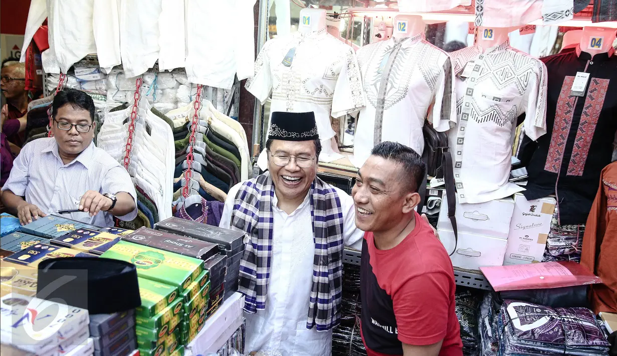 Mantan Menko Maritim,  Rizal Ramli melihat baju-baju saat berkunjung ke Blok A, Pasar Tanah Abang, Jakarta, Sabtu (13/8). Kunjungannya tersebut terkait pencalonannya sebagai cagub pada Pilkada DKI Jakarta 2017.(Liputan6.com/Faizal Fanani)