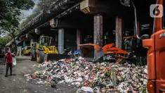 Petugas PPSU menggunakan kendaraan alat berat untuk mengangkut tumpukan sampah di kolong tol Wiyoto Wiyono, Tanjung Priok, Jakarta, Selasa (5/11/2019). Kolong Tol Tol Wiyoto-Wiyono berubah menjadi tempat penampungan sampah rumah tangga dari tiga kelurahan di kawasan itu. (Liputan6.com/Faizal Fanani)