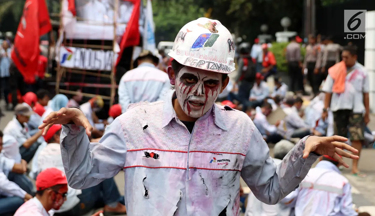 Seorang peserta aksi berdandan seperti zombi melakukan demo di depan gedung Pertamina, Jakarta, Senin (23/10). Mereka juga meminta bertemu dengan Presiden Joko Widodo (Jokowi) untuk mendengarkan tuntutan mereka. (Liputan6.com/Angga Yuniar)