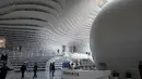 Sejumlah pengunjung melihat buku koleksi Perpustakaan Binhai Tianjin di China (14/11). Perpustakaan ini memiliki desain futuristik, dengan interior serba putih dan rak susun melingkar. (AFP/Fred Dufour)