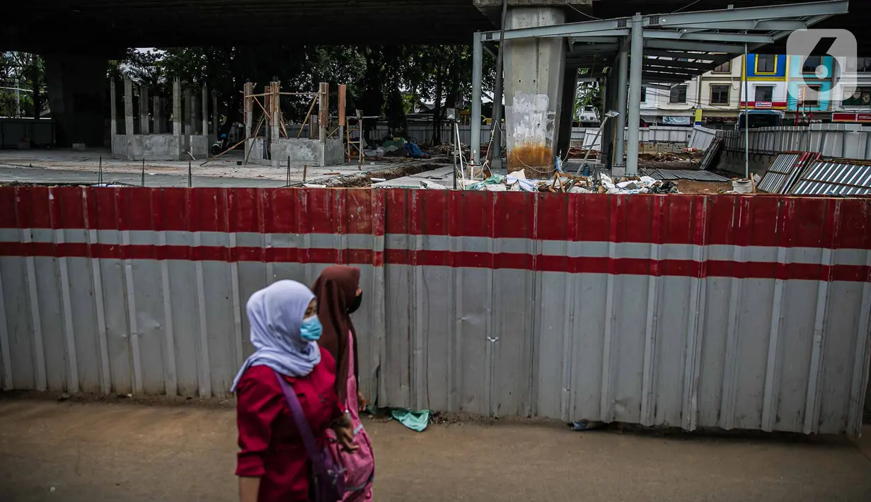 Pejalan kaki melintas di dekat area proyek penataan Stasiun Tebet, Jakarta, Senin (28/12/2020). Pemerintah Provinsi DKI Jakarta melakukan penataan kawasan Stasiun Tebet untuk mengoptimalkan integrasi antarmoda bagi penumpang yang mengakses transportasi kereta api. (Liputan6.com/Faizal Fanani)