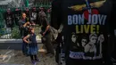 Seorang pengunjung membeli kaos Bon Jovi yang dijajakan pedagang di luar Stadion Gelora Bung Karno, Jakarta, Jumat (11/9/2015). Grup band asal Amerika itu akan menggelar konser ‘Bon Jovi Live! Jakarta' nanti malam di arena GBK.(Liputan6.com/Faizal Fanani)