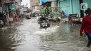 Pengendara sepeda motor menerjang banjir rob di Muara Angke, Jakarta, Jumat (25/11/2022). Badan Penanggulangan Bencana Daerah (BPBD) DKI Jakarta mengimbau agar warga di pesisir Jakarta mengantisipasi banjir pesisir atau rob selama 22-28 November 2022. (Liputan6.com/Faizal Fanani)