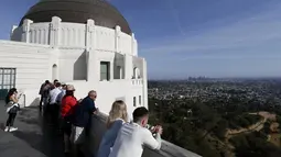 Wisatawan melihat pemandangan Kota Los Angeles dari puncak bangunan Griffith Observatory & Planetarium, California (14/3/2016). (Reuters/ Mario Anzuoni)