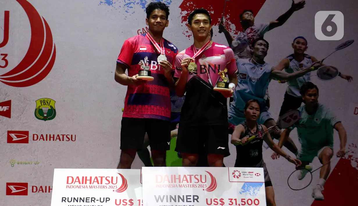 Pebulu tangkis tunggal putra Indonesia Jonatan Christie dan rekan senegaranya Chico Aura Dwi Wardoyo berpose dengan trofi Indonesia Masters 2023 usai bertanding di Istora Senayan, Jakarta, Minggu (29/1/2023).  Jonatan Christie untuk pertama kalinya menjuarai turnamen bulu tangkis berlevel BWF Super 500 menyusul kemenangan pada ajang Indonesia Masters 2023. (Liputan6.com/Herman Zakharia)