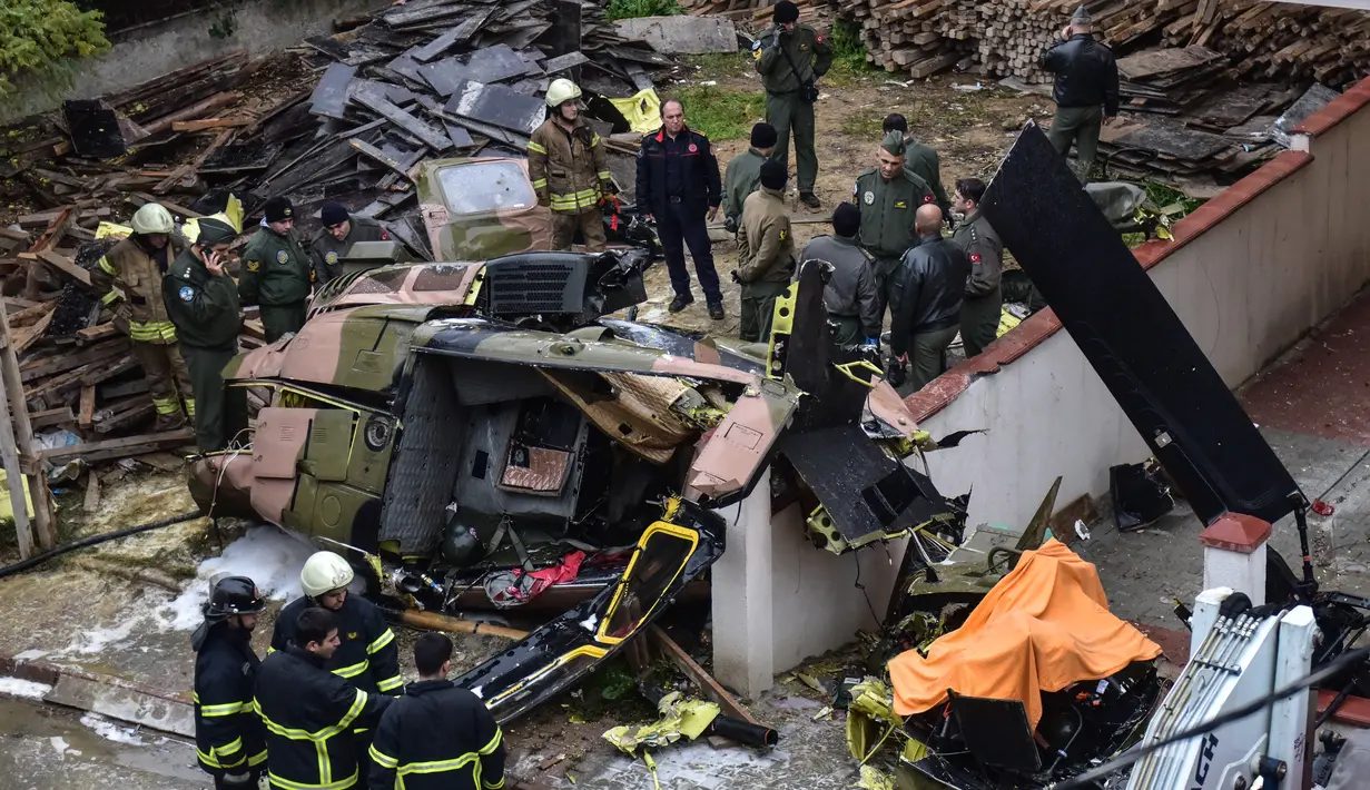 Regu penyelamat dan tim penyelidik berada di lokasi jatuhnya helikopter militer di lingkungan perumahan di Istanbul, Turki, Senin (26/11). Kecelakaan helikopter tersebut menewaskan empat dari lima tentara di dalamnya. (HO / DHA / AFP)
