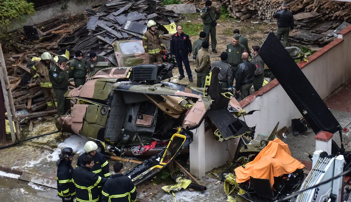 Regu penyelamat dan tim penyelidik berada di lokasi jatuhnya helikopter militer di lingkungan perumahan di Istanbul, Turki, Senin (26/11). Kecelakaan helikopter tersebut menewaskan empat dari lima tentara di dalamnya. (HO / DHA / AFP)