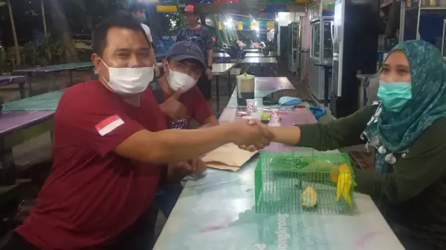 Didik Saputra (Kiri) menukar mobil CRV 2009 miliknya dengan sepasang lovebird. (Dian KUrniawan/Liputan6.com)