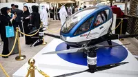 Pengunjung mengambil gambar drone atau pesawat tanpa awak EHang 184 yang dipamerkan di World Government Summit 2017, Dubai, Senin (13/2). EHang 184 ini mampu terbang hingga jarak 50 kilometer dengan kecepatan maksimum 160 km per jam. (STRINGER/AFP)