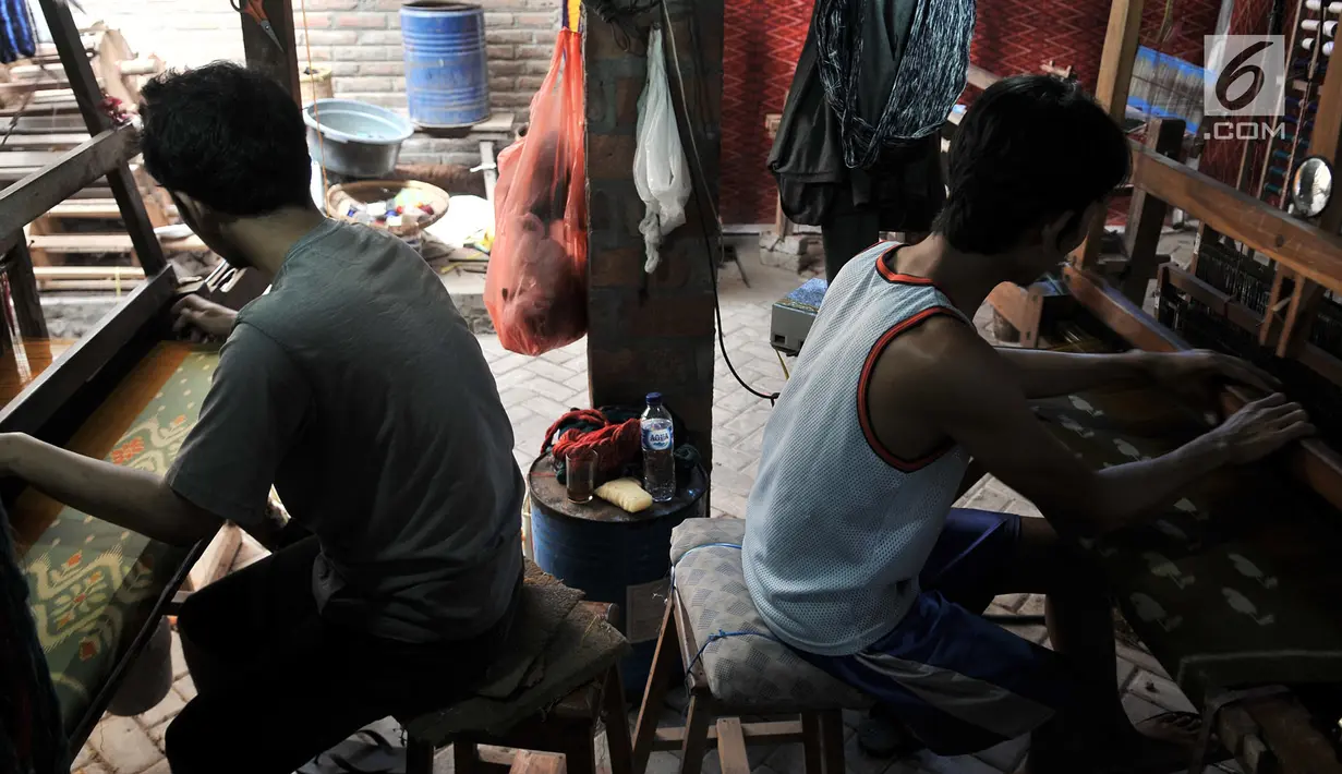 Pengrajin saat menyelesaikan pembuatan tenun ikat di salah satu industri rumahan di Desa Bandar Kidul, Kediri, Jawa Timur, Sabtu (29/9). Industri tenun ikat Kediri menjadi sumber kehidupan utama bagi warga Bandar Kidul. (Merdeka.com/Iqbal Nugroho)