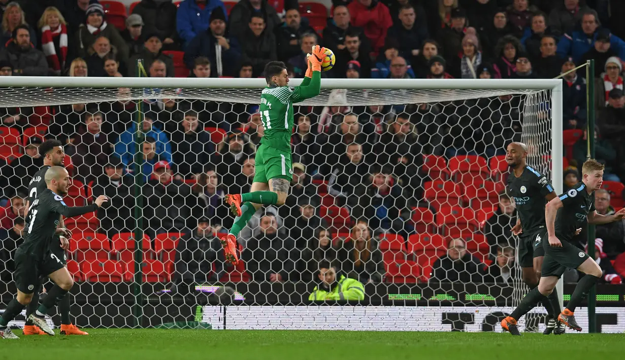 Kiper Manchester City Ederson menangkap bola saat bertandang ke markas Stoke City pada pertandingan pekan ke-30 Premier League di bet365 Stadium, Selasa (13/3). City kian mendekati gelar Liga Primer Inggris musim ini lewat kemenangan 2-0. (PAUL ELLIS/AFP)