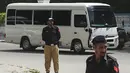 Petugas polisi berjaga-jaga saat pemain kriket Inggris dan ofisial tim melakukan perjalanan dengan bus saat tiba di hotel mereka di Karachi pada 15 September 2022. Tim kriket Inggris tiba di Pakistan setelah 17 tahun, untuk memainkan tujuh pertandingan kriket Twenty20, mulai dari 20 September. (AFP Photo/Rizwan Tabassum)