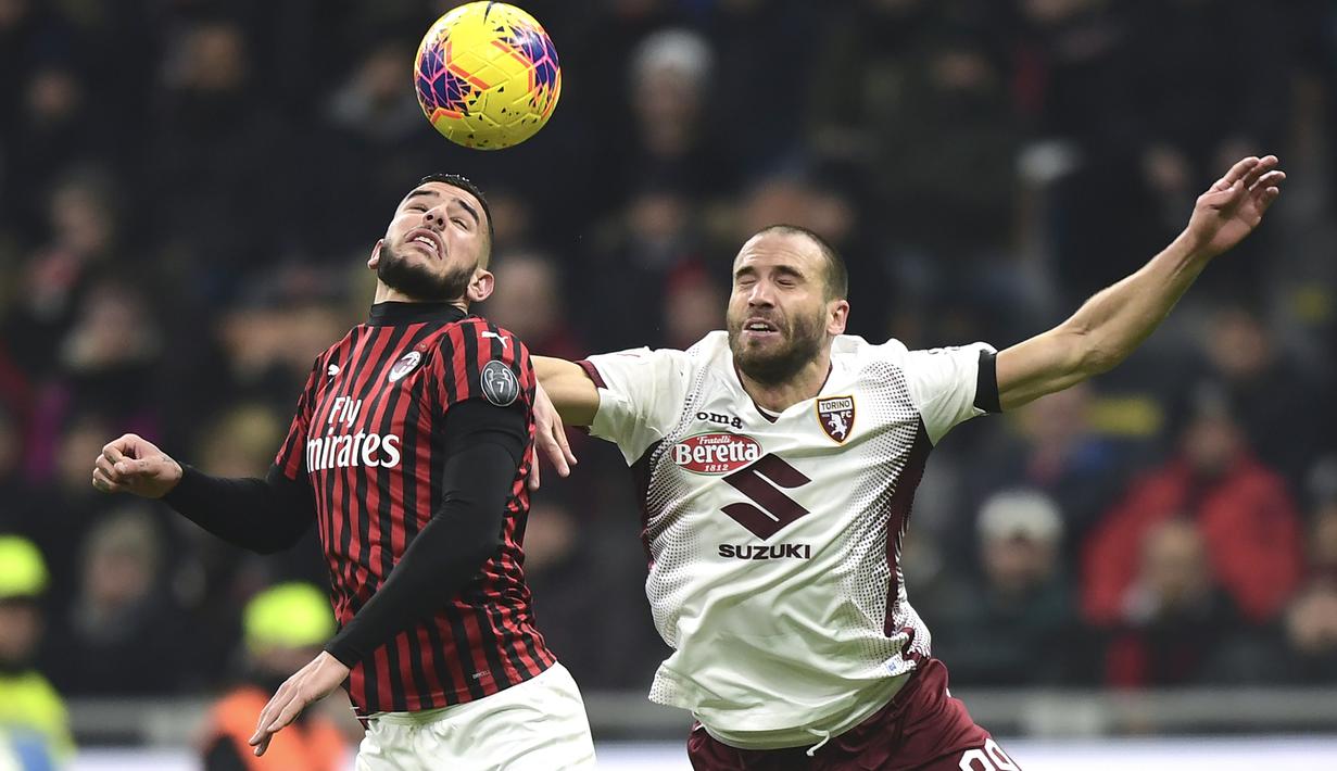 Bek AC Milan, Theo Hernandez, duel udara dengan bek Torino, Lorenzo De Silvestri, pada laga Coppa Italia di Stadion San Siro, Milan, Selasa (28/1). Milan menang 4-2 atas Torino. (AFP/Miguel Medina)