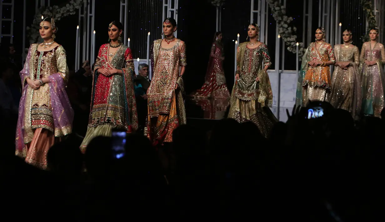 Model membawakan busana rancangan desainer Annus Abrar  selama Bridal Couture Week di Lahore, Minggu (9/12). Para model cantik memperagakan kreasi gaun pengantin dari sejumlah desainer ternama di Pakistan. (AP Photo/K.M. Chaudary)