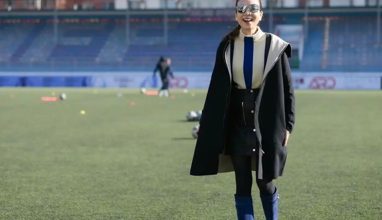 Meski di tengah lapangan, Madam Pang tetap tampil fashionable dengan coat hitam dan dalaman berupa turtleneck. (Instagram/panglamsam).