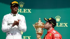 Pembalap Ferrari, Sebastian Vettel (benar) mencium piala di depan pembalap Mercedes, Lewis Hamilton (kiri) saat menjuarai F1 GP di Sirkuit Silverstone, Inggris, Minggu (8/7). Vettel mengungguli Lewis Hamilton dan Kimi Raikkonen. (AP Foto/Luca Bruno)