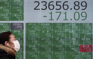 Seorang wanita berjalan melewati layar monitor yang menunjukkan indeks bursa saham Nikkei 225 Jepang dan lainnya di sebuah perusahaan sekuritas di Tokyo, Senin (10/2/2020). Pasar saham Asia turun pada Senin setelah China melaporkan kenaikan dalam kasus wabah virus corona. (AP Photo/Eugene Hoshiko)