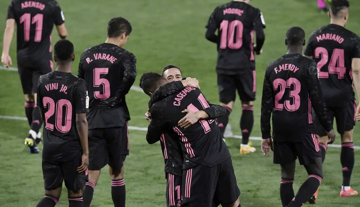 Pemain Real Madrid, Casemiro dan Lucas Vazquez, merayakan gol ke gawang Real Valladolid pada laga Liga Spanyol di Stadion Jose Zorrila, Minggu (21/2/2021). Real Madrid menang dengan skor 1-0. (AP/Alvaro Barrientos)