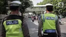 Pengendara sepeda motor melintas saat polisi lalu lintas berjaga pada Operasi Zebra Jaya 2022 di Jakarta, Selasa (4/10/2022). Operasi Zebra Jaya dilaksanakan pada tanggal 3 hingga 17 Oktober untuk menekan jumlah pelanggaran lalu lintas. (Liputan6.com/Faizal Fanani)