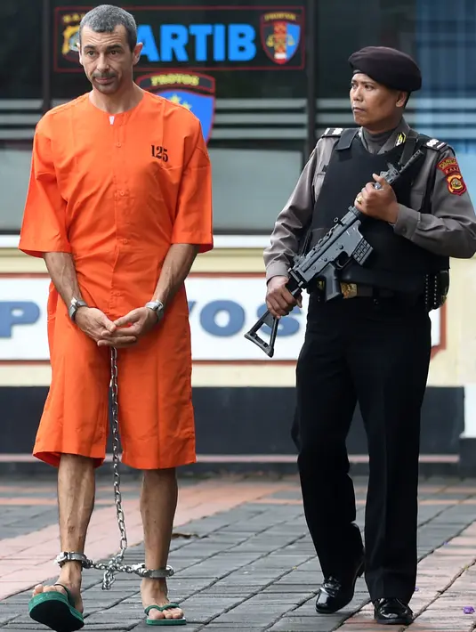 Warga negara Prancis Samuel Pierre Danguny dikawal oleh polisi sebelum konferensi pers di kantor polisi di Denpasar, Bali (18/3). Danguny ditangkap pada 15 Maret dengan kepemilikan 33 gram ganja dan 2 paket Hasis 16 gram. (AFP Photo/Sonny Tumbelaka)