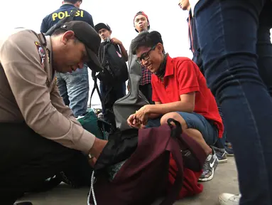 Anggota Polres Kepulauan Seribu memeriksa tas wisatawan di Kali Adem, Jakarta, Kamis (5/5). Razia tersebut sebagai bentuk pencegahan penyalahgunaan narkoba dan minuman keras. (Liputan6.com/Angga Yuniar) 