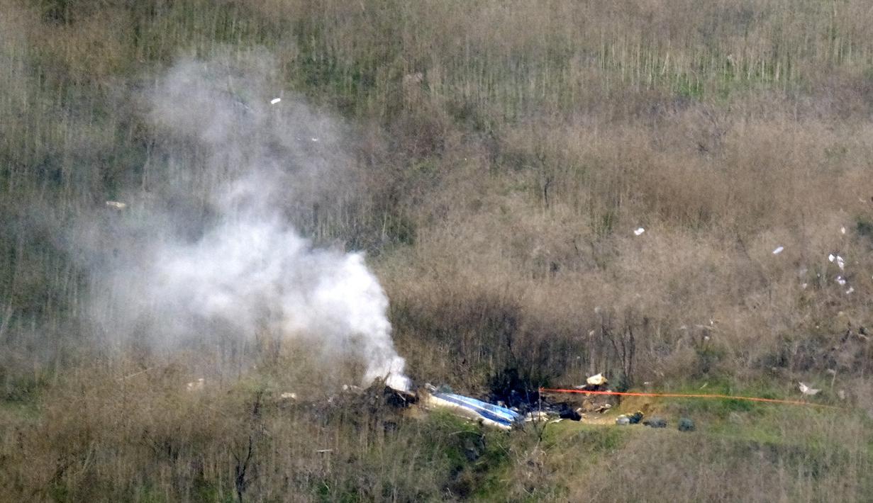 Asap mengepul saat jatuhnya helikopter di Calabasas, California, Minggu (26/1/2020). Legenda NBA, Kobe Bryant, menjadi salah satu korban tewas pada kecelekaan helikopter berjenis Sikorsky S-76B itu. (AP/Richard Vogel)
