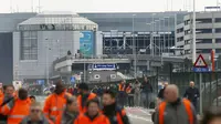 Calon penumpang berjalan meninggalkan lokasi ledakan di Bandara Zaventem dekat Brussels, Belgia, (22/3). Sedikitnya 13 orang tewas akibat ledakan beruntun yang mengguncang ruang keberangkatan bandara tersebut. (REUTERS / Francois Lenoir)