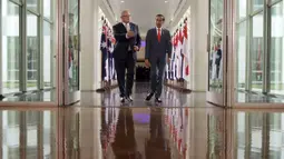 Presiden Joko Widodo (kanan) dan PM Australia Scott Morrison berjalan melalui jalur penghubung saat mereka meninggalkan Dewan Perwakilan di Gedung Parlemen di Canberra, Australia Senin, (10/2/2020). (Tracey Nearmy/Pool Photo via AP)