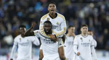 Pemain Real Madrid, Antonio Rudiger dan Jude Bellingham merayakan kemenangan tim mereka saat melawan Deportivo Alaves pada laga La Liga 2023/2024 jornada 18 di Estadio Mendizorroza, Jumat (22/12/2023) dini hari WIB. (AP Photo/Ricardo Larreina)