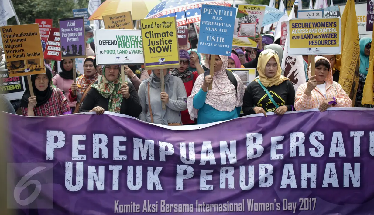 Puluhan massa aksi yang tergabung dalam beberapa aktivis wanita membawa spanduk saat menggelar aksi unjuk rasa dikawasan Patung Kuda, Jakarta, Rabu (8/3). (Liputan6.com/Faizal Fanani)
