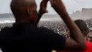 Pengunjung mengabadikan keramaian saat liburan awal Tahun Baru 2017 di sebuah pantai di Durban, Afrika Selatan (1/1). (REUTERS/Rogan Ward)