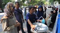 Warga mengisi air ke botol dari Keran Air Siap Minum (KASM) yang terpasang di dekat Pintu 2 Kebun Raya Bogor, Jawa Barat, Minggu (6/10/2019). Pemkot Bogor melalui PDAM Tirta Pakuan membuat KASM untuk menekan angka konsumsi botol dan gelas plastik. (merdeka.com/Arie Basuki)