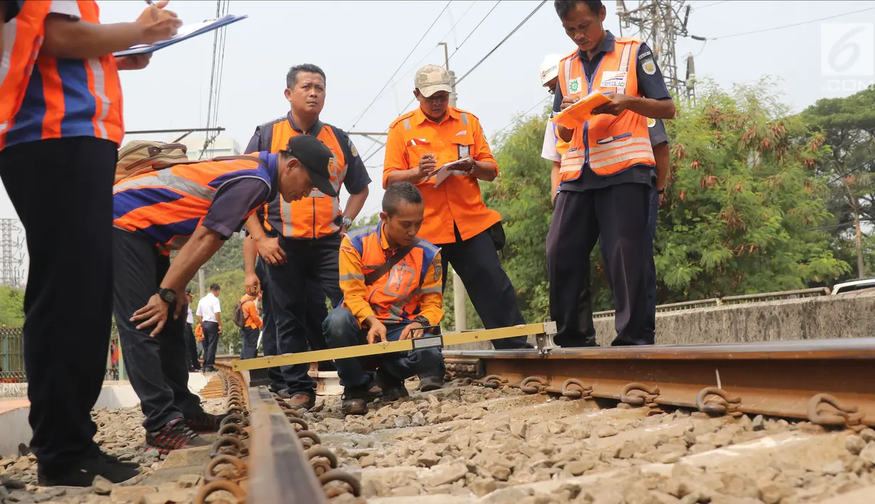 Sejumlah petugas KAI memeriksa rel kereta di dekat Stasiun Palmerah, Jakarta, Sabtu (13/10). Perjalanan KRL lintas Tanah Abang hingga Rangkasbitung dilakukan bergantian jalur hingga perbaikan selesai. (Liputan6.com/Herman Zakharia)