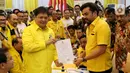 Ketua Umum Golkar Airlangga Hartarto menyerahkan berkas pendaftaran bakal calon ketua umum (caketum) Partai Golkar kepada Ketua Komite Pemilihan Maman Abdulrahman (kanan) di DPP Partai Golkar, Jakarta, Senin (2/12/2019). (Liputan6.com/Johan Tallo)