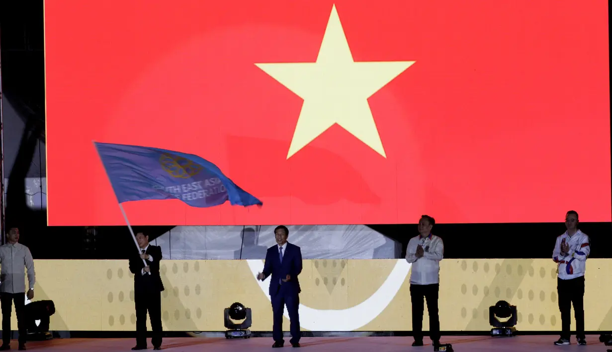 Perwakilan Vietnam menerima mandat untuk tuan rumah selanjutnya saat upacara penutupan SEA Games 2019 di Stadion New Clark City, Filipina, Rabu (11/12). Filipina menjadi juara umum pada gelaran kali ini. (Bola.com/M Iqbal Ichsan)