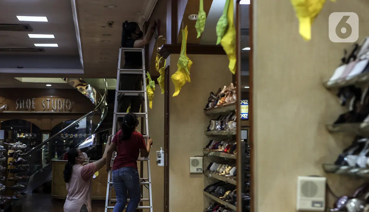 Karyawan memasang ornamen untuk mempercantik toko jelang bulan suci Ramadhan di Pasar Baru, Jakarta, Rabu (9/3/2022). Selain untuk mempercantik toko, pemasangan ornamen juga untuk menarik perhatian pengunjung atau warga yang hendak berbelanja ke toko tersebut. (Liputan6.com/Johan Tallo)