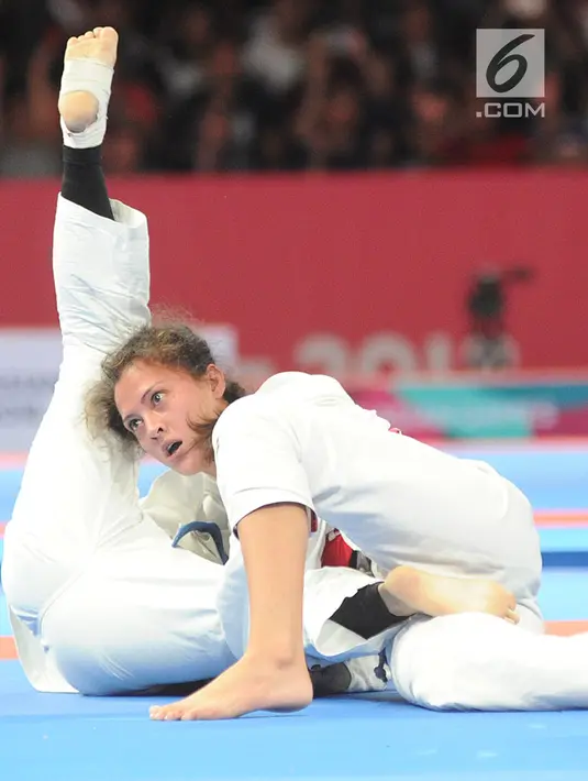 Atlet Jujitsu putri Indonesia Simone Julia mengunci Tsogkhuu Udval dari Mongolia saat bertanding pada nomor final putri 62 kg Asian Games 2018, Jakarta, Sabtu (25/8). Simone gagal mempersembahkan medali perunggu. (Merdeka.com/Arie Basuki)